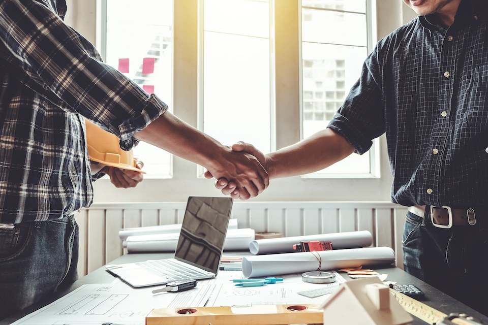 A Jax Roofing handshake with a homeowner over project plans