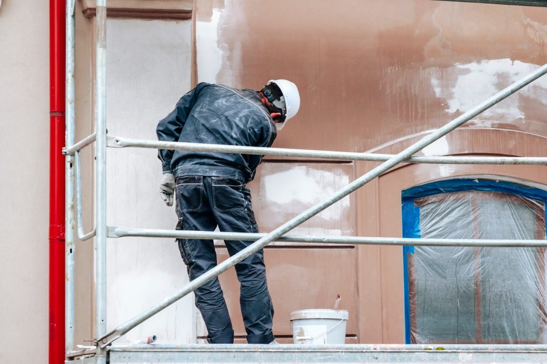 A painter working from scaffolding on a home exterior